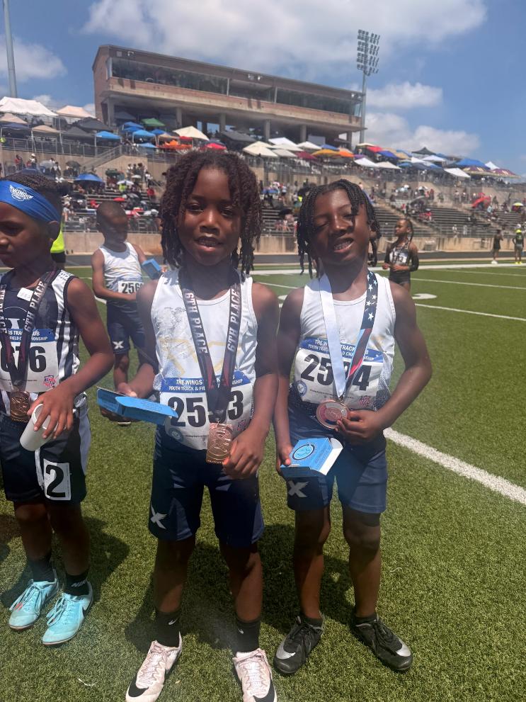 Two young TSE athletes with medals on the infield