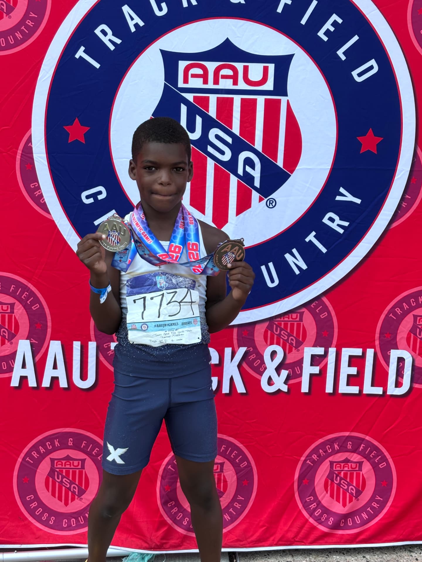 TSE athlete holding two AAU Junior Olympic medals